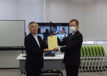 報告書を手渡しする長澤悟委員長（左）とそれを受けとる坂田篤教育長（右）
