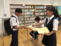 写真：生徒が紙を渡している様子