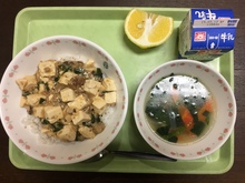 牛乳、麻婆丼、五目スープ、はるみオレンジの写真